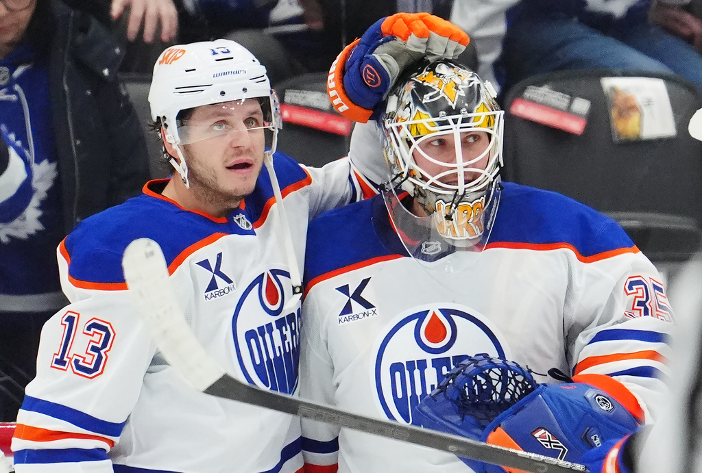 Edmonton Oilers' Connor McDavid, left to right, goaltender Tristan Jarry (35) and goaltender Calvin Pickard (30) celebrate after defeating the Toronto Maple Leafs in an NHL hockey game in Toronto on Saturday, Dec. 13, 2025. (Frank Gunn/The Canadian Press via AP)