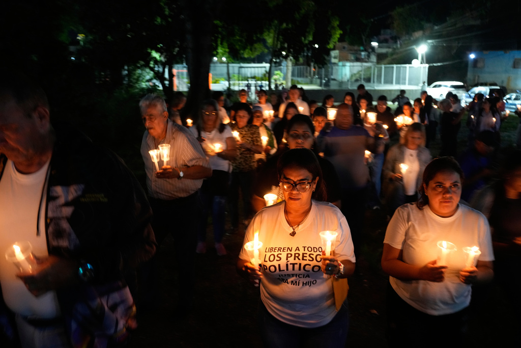 Relatives and friends of political prisoners hold candles calling for their loved ones to be set free outside the Rodeo I prison in Guatire, Venezuela, Friday, Jan. 9, 2026 after the government announced prisoners would be released. (AP Photo/Matias Delacroix)