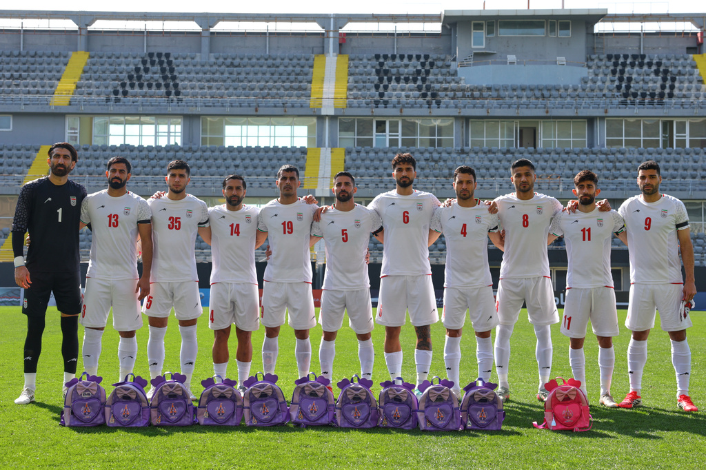 Iran's players pose for a photographer next to school bags, symbolizing children allegedly killed in a U.S. strike on a school in Minab, before a friendly soccer match between Iran and Nigeria, in Antalya, southern Turkey, Friday, March 27, 2026. (AP Photo/Riza Ozel)