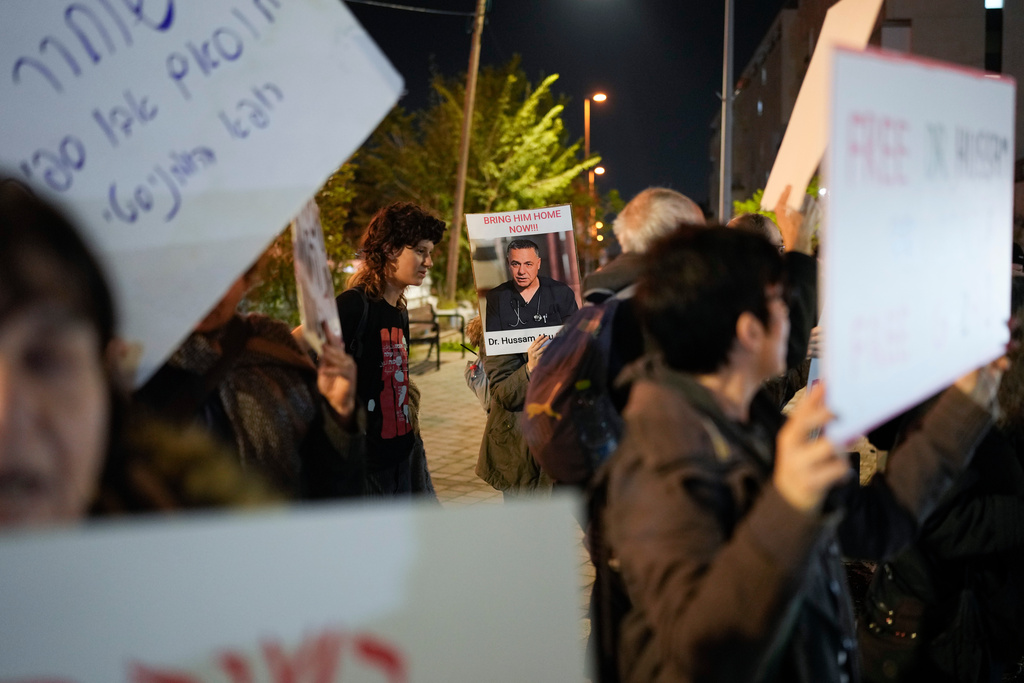 FILE - A woman holds a sign with a photo of Palestinian Dr. Hussam Abu Safiya during a protest calling for his release in front of the Shin Bet offices in Tel Aviv, Israel, Jan. 1, 2025. (AP Photo/Matias Delacroix, File)