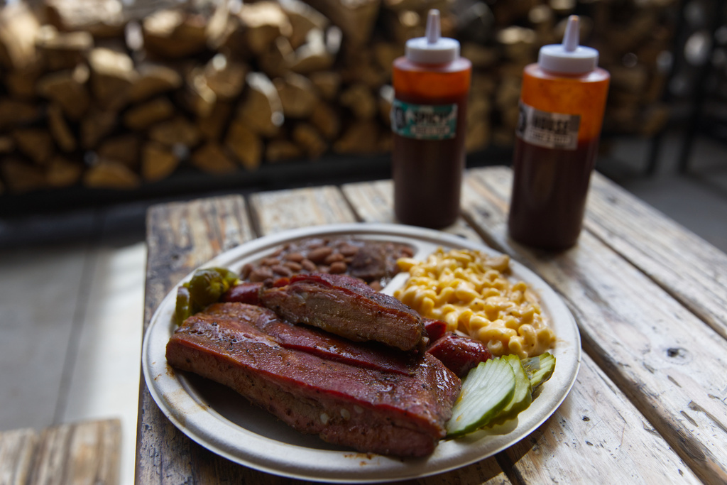 A plate of ribs and sausage with two sides is served at the Little Miss BBQ in Phoenix, Tuesday May 19, 2026. (AP Photo/Dario Lopez-Mills)