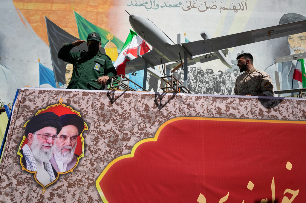 A member of Iran's Revolutionary Guard salutes while riding on a float displaying drones during the state-organized "Janfada," or "Sacrifice for Iran," military-style parade in Tehran, Iran, Friday, Sept. 18, 2026. (AP Photo/Vahid Salemi)