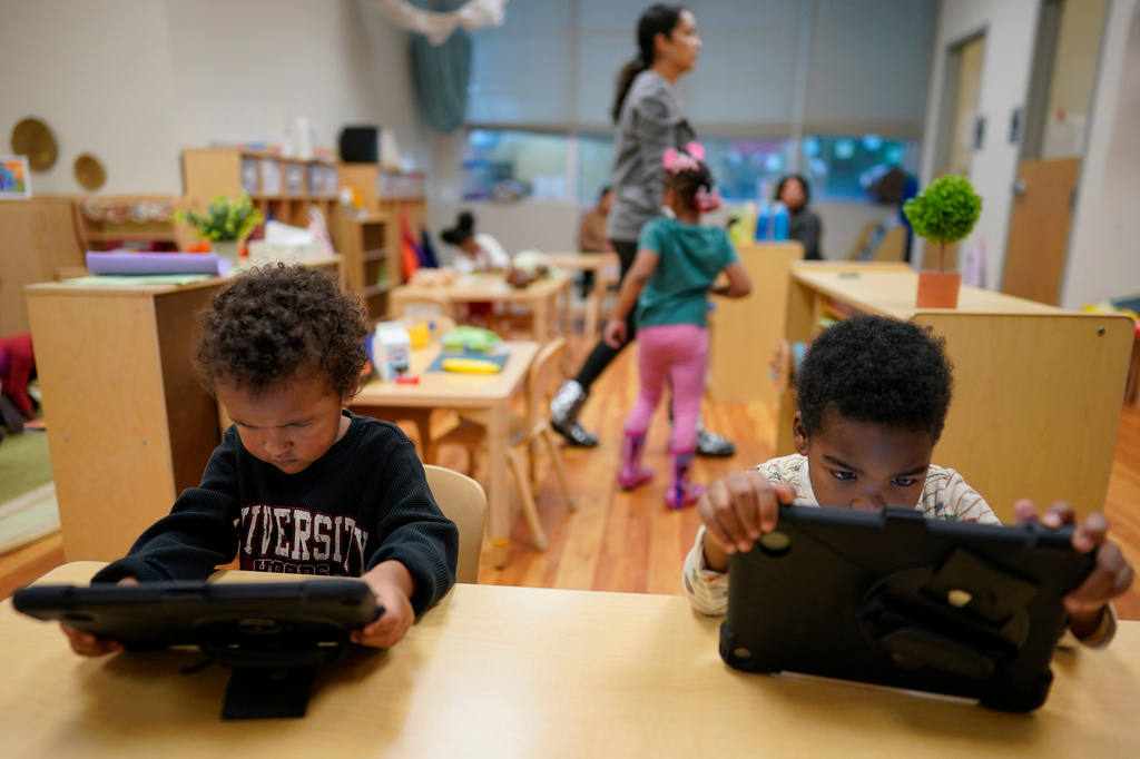 FILE - Children work on tablets during a preschool class at the Life Learning Center - Head Start, in Cincinnati, Nov. 21, 2023. (AP Photo/Carolyn Kaster, File)