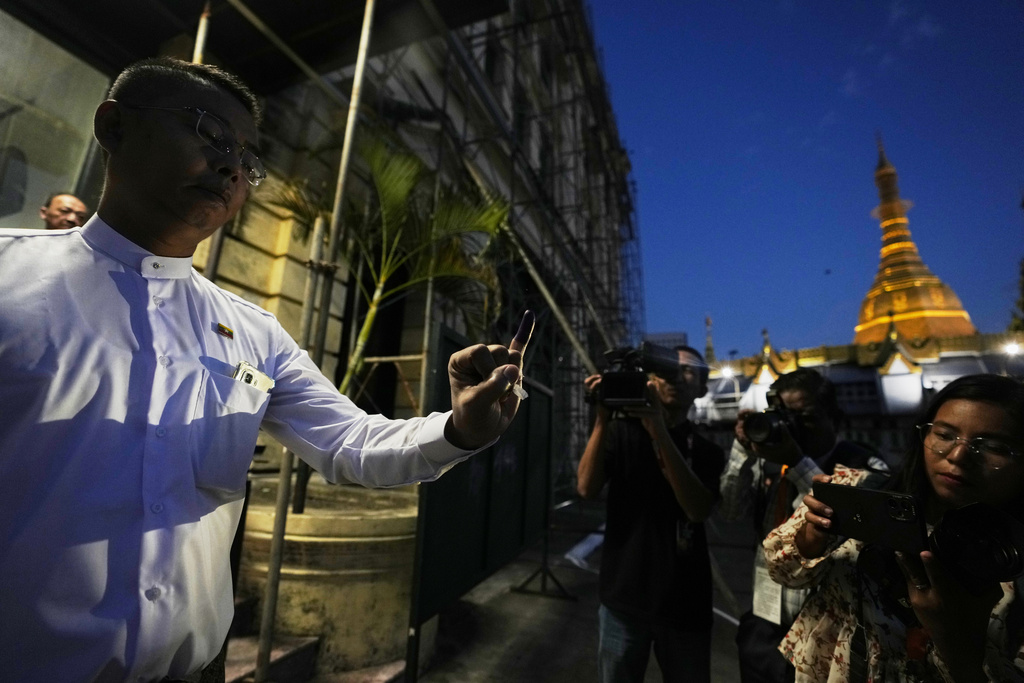 A voter shows off her finger marked with ink indicating she voted as she leaves a polling station, Sunday, Dec. 28, 2025, in Yangon, Myanmar. (AP Photo/Thein Zaw)