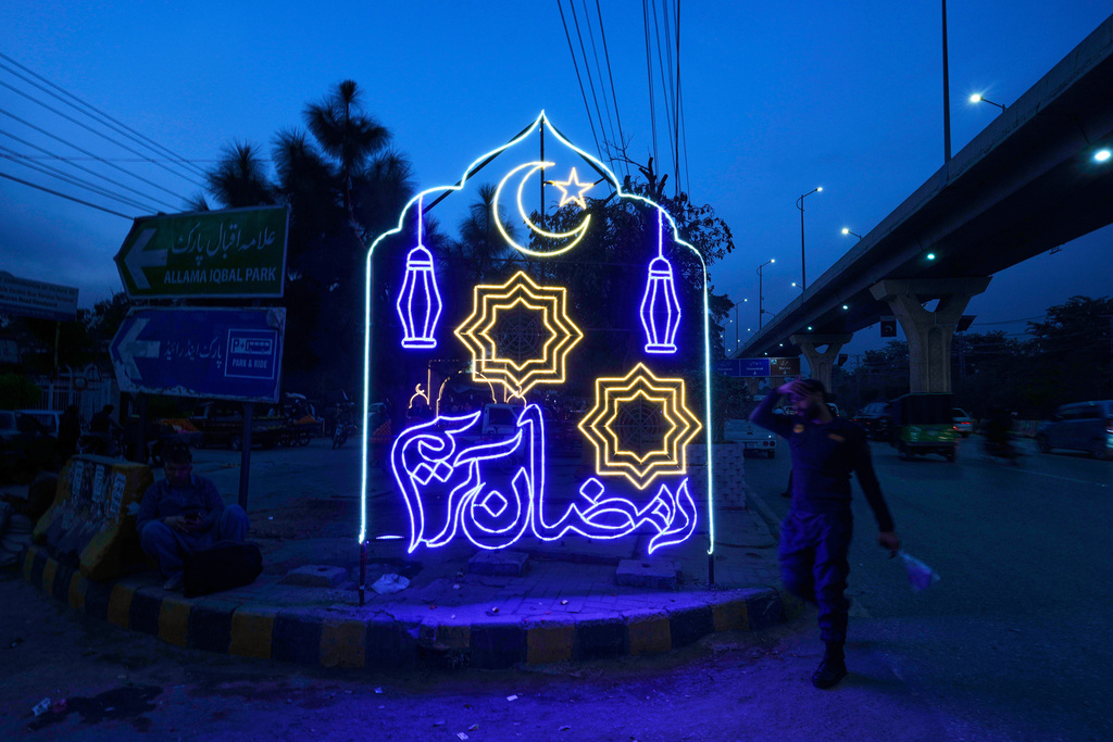A man walks past a neon light decoration with wording 'Ramadan Kareem' placed by local authorities in connection with upcoming Muslims holy fasting month of Ramadan, in Rawalpindi, Pakistan, Tuesday, Feb. 17, 2026. (AP Photo/Anjum Naveed)
