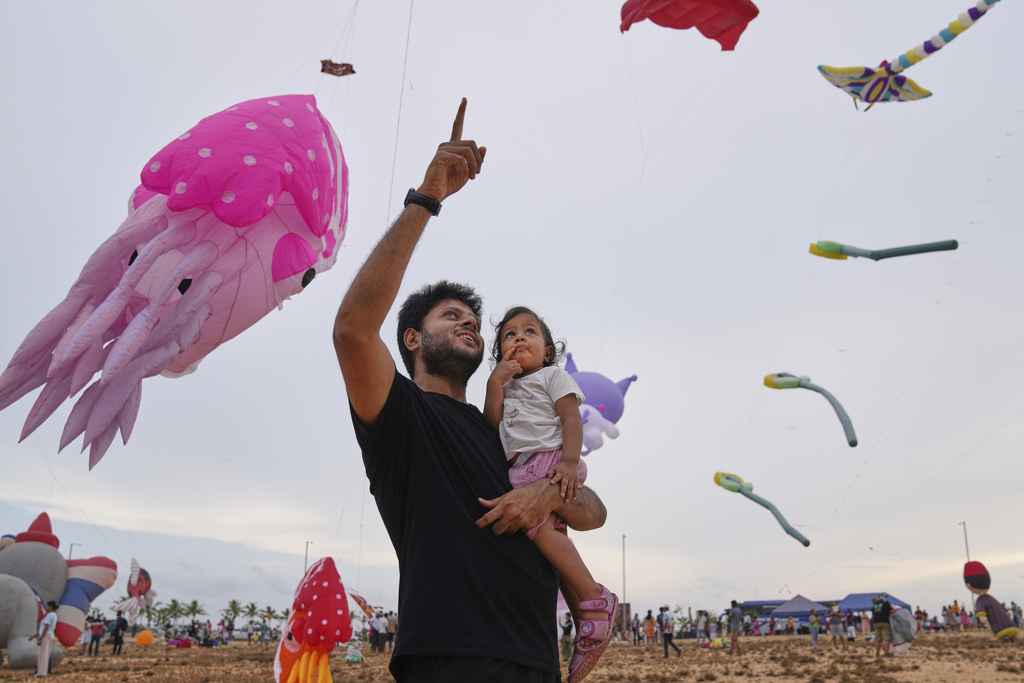 A man and his daughter attend the Colombo International Kite Festival in Colombo, Sri Lanka, Saturday, Aug. 23, 2025. (AP Photo/Eranga Jayawardena)