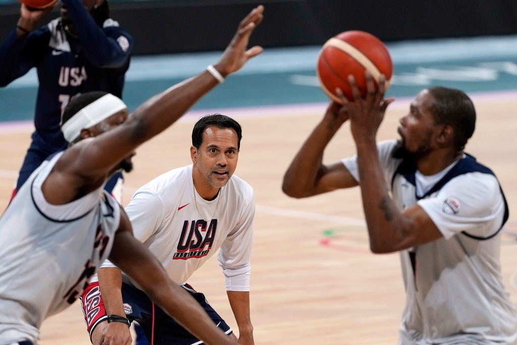 FILE - United State's Kevin Durant, right, shoots as Bam Adebayo, left, defends while assistant coach Erik Spoelstra watches during men's basketball practice at the 2024 Summer Olympics, Wednesday, July 24, 2024, in Villeneuve-d'Ascq, France. (AP Photo/Mark J. Terrill, File)
