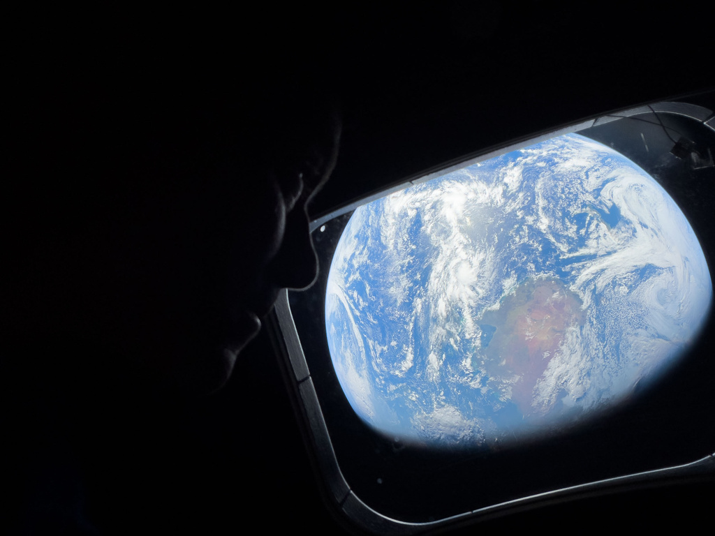 This image provided by NASA, astronaut and Artemis II Commander Reid Wiseman peers out of one of the Orion spacecraft's main cabin windows, looking back at Earth, as the crew travels towards the Moon on Thursday, April 2, 2026. (NASA via AP)