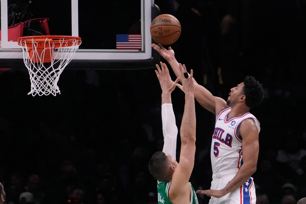 Philadelphia 76ers guard Quentin Grimes (5) drives to the basket against Boston Celtics center Nikola Vucevic (4) during the first half of Game 2 of a first-round NBA playoffs basketball series, Tuesday, April 21, 2026, in Boston. (AP Photo/Charles Krupa)