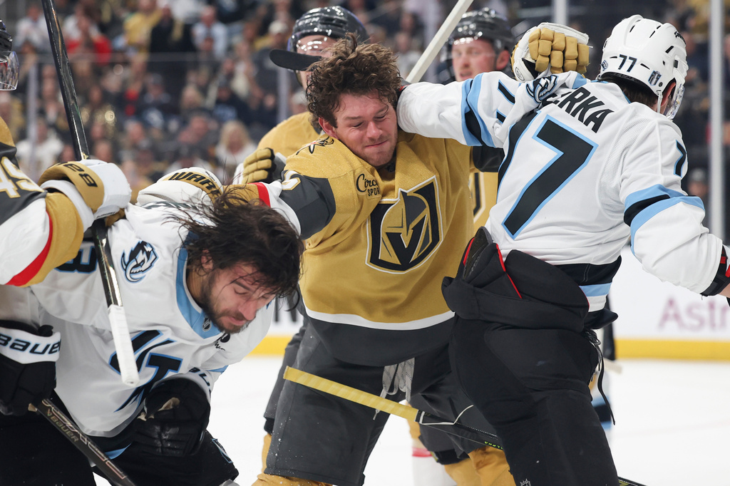 Vegas Golden Knights defenseman Jeremy Lauzon (5) punches Utah Mammoth left wing Brandon Tanev (13) during the first period in Game 2 of a first-round NHL hockey Stanley Cup playoff series Tuesday, April 21, 2026, in Las Vegas. (AP Photo/Ian Maule)