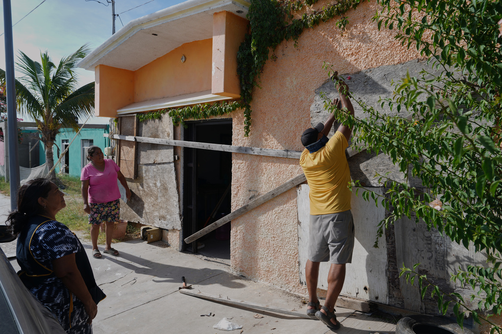 A man boards up a house's windows as Hurricane Polo approaches in Puerto San Carlos, Baja California Sur state, Mexico, Sunday, Sept. 27, 2026. (AP Photo/Eduardo Verdugo)