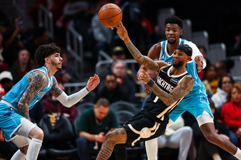 Atlanta Hawks guard Nickeil Alexander-Walker, right, passes the ball against Charlotte Hornets guard LaMelo Ball, left, during the first half of an NBA basketball game, Saturday, Feb. 7, 2026, in Atlanta. (AP Photo/Colin Hubbard)