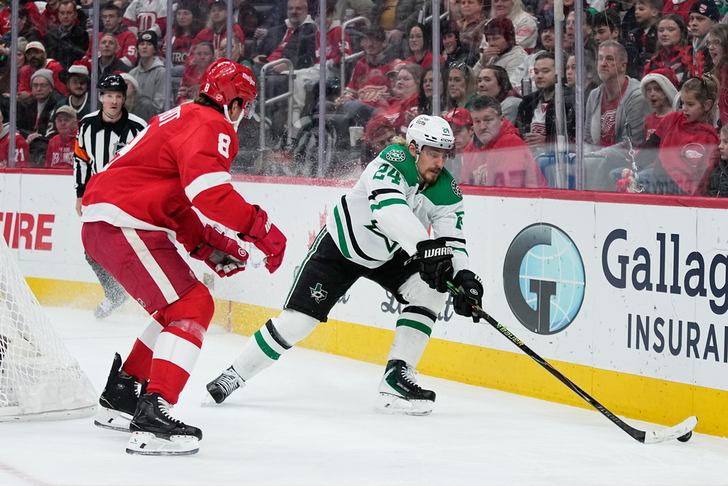 Dallas Stars center Roope Hintz, left, moves the puck against Detroit Red Wings defenseman Ben Chiarot during the first period of an NHL hockey game Tuesday, Dec. 23, 2025, in Detroit. (AP Photo/Ryan Sun)