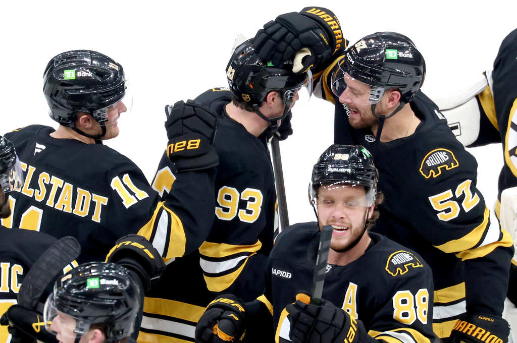 Boston Bruins center Fraser Minten (93) and teammates, including center Sean Kuraly (52), celebrate after his winning goal in overtime during an NHL hockey game against the Chicago Blackhawks, Thursday, Oct. 9, 2025, in Boston. (AP Photo/Mark Stockwell)