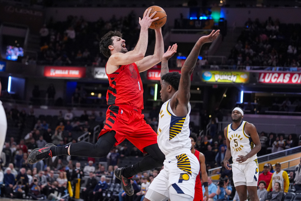 Portland Trail Blazers forward Deni Avdija (8) draws the foul from Indiana Pacers guard Kam Jones (7) as he shoots during the second half of an NBA basketball game in Indianapolis, Wednesday, March 18, 2026. (AP Photo/Michael Conroy)