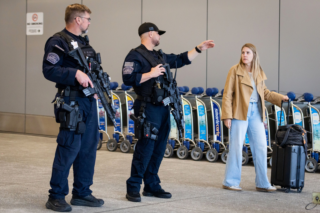 A traveler speaks to police officers at Los Angeles International Airport on Monday, March 23, 2026, in Los Angeles. (AP Photo/Ethan Swope)