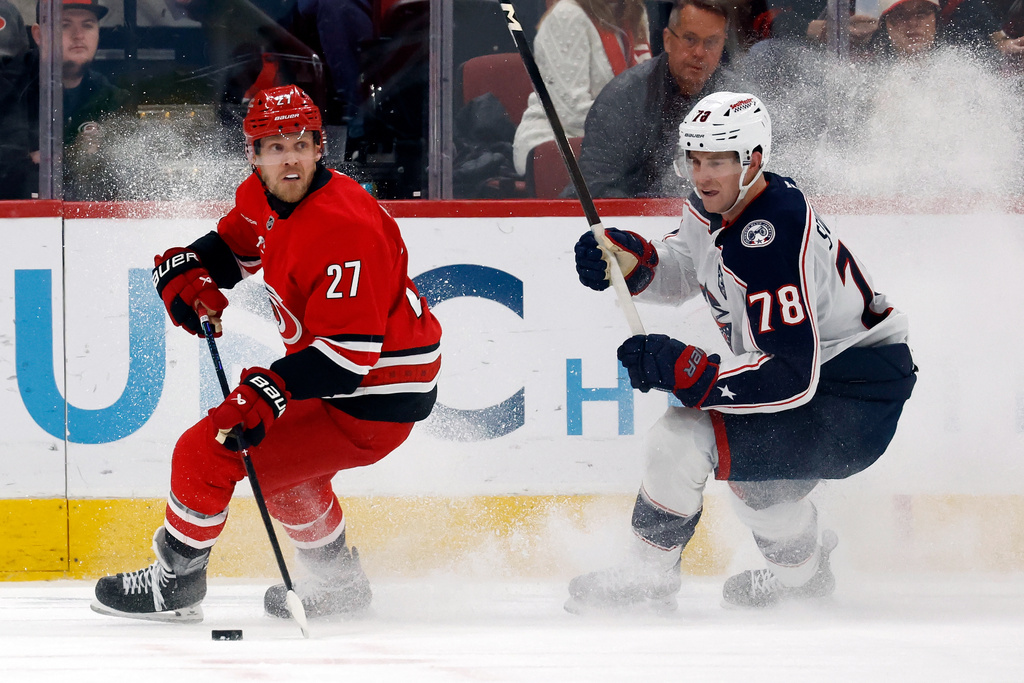 Carolina Hurricanes' Nikolaj Ehlers (27) controls the puck in front of Columbus Blue Jackets' Damon Severson (78) during the third period of an NHL hockey game in Raleigh, N.C., Tuesday, Dec. 9, 2025. (AP Photo/Karl DeBlaker)