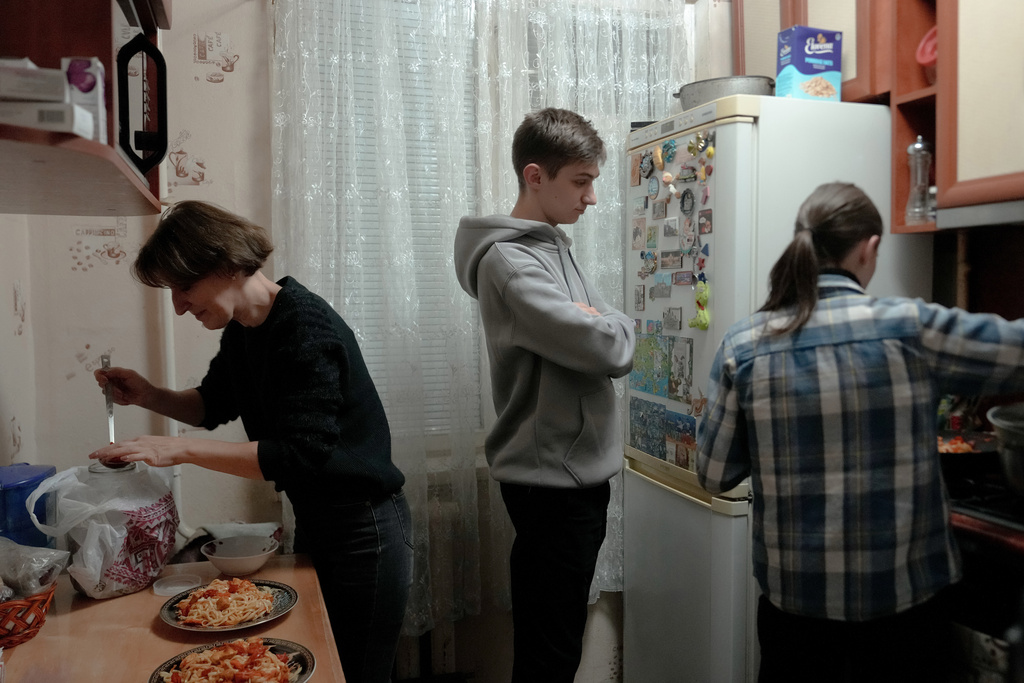 Liudmyla cooks dinner with her daughter Oksana and son-in-law Zhenya, who have been coming over most days to make sure Lubya eats, following the death of her husband, Friday, Oct. 31, 2025, in Chernihiv, Ukraine. (AP Photo/Julia Demaree Nikhinson)