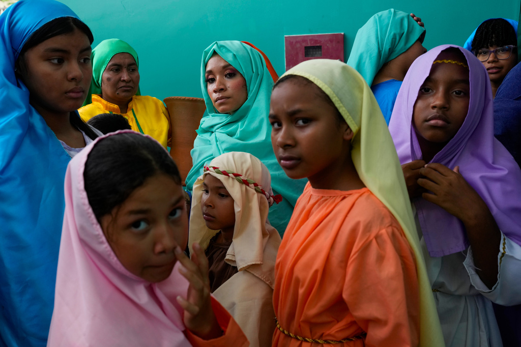 Devotees dressed as townspeople prepare to enter the stage to perform in a Way of the Cross reenactment in Arraijan, Panama, Friday, April 3, 2026. (AP Photo/Matias Delacroix)