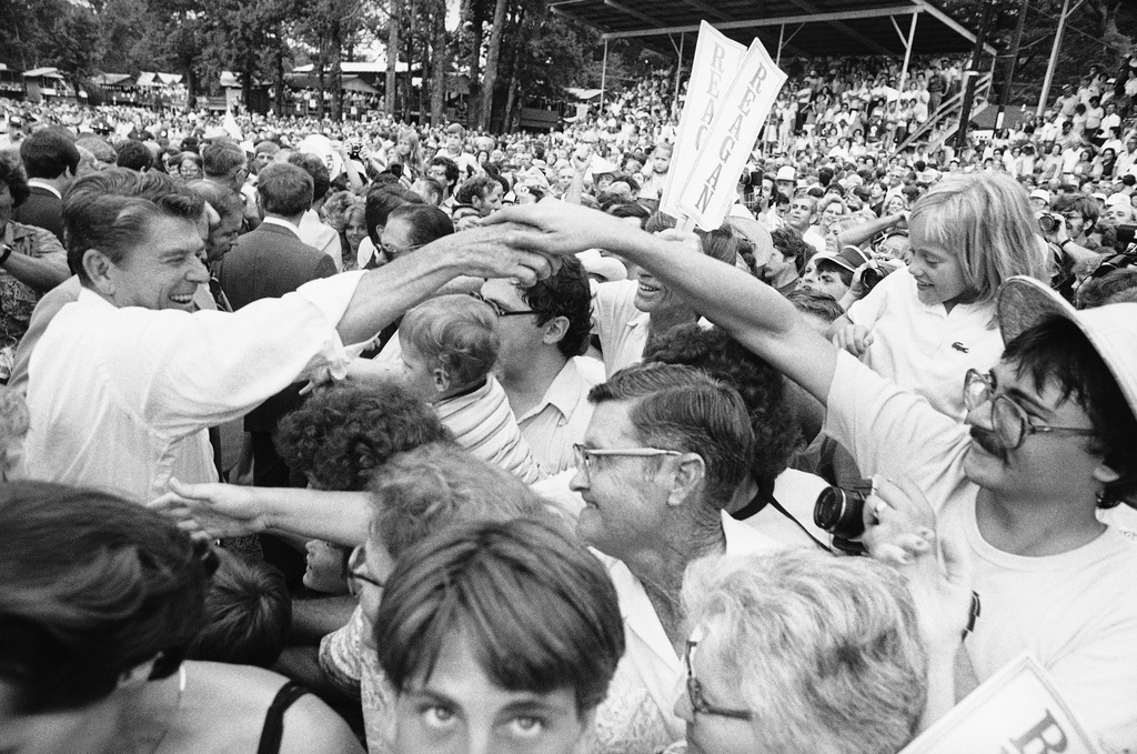 FILE - Republican presidential candidate Ronald Reagan, left, moves through the crowd shaking hands at the Neshoba County Fair in Philadelphia, Mississippi, Aug. 3, 1980. (AP Photo/Jack Thornell, File)