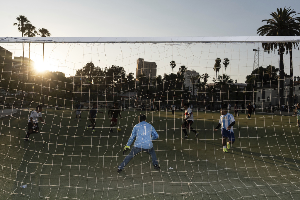 People play soccer during sunset in MacArthur Park, an area that was recently targeted in ICE raids, in Los Angeles, Tuesday, Aug. 5, 2025. (AP Photo/Jae C. Hong)