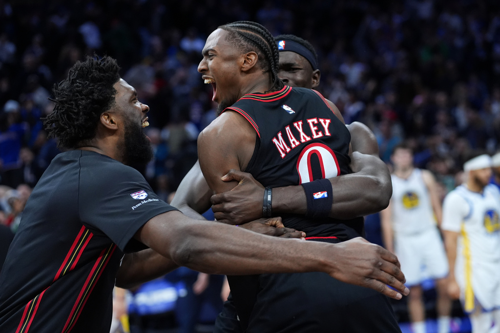 Philadelphia 76ers' Joel Embiid, from left, Tyrese Maxey and Adem Bona celebrate after the 76ers won an NBA basketball game against the Golden State Warriors Thursday, Dec. 4, 2025, in Philadelphia. (AP Photo/Matt Slocum)