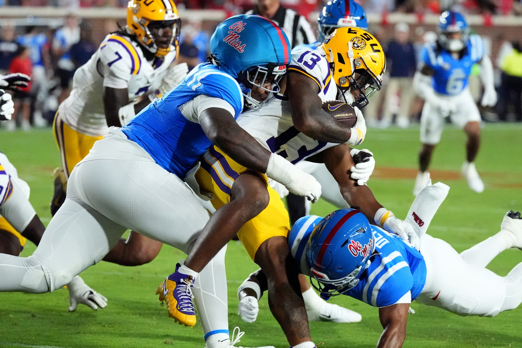 LSU running back Dilin Jones (13) is tackled by Mississippi defensive end Kam Franklin, left, after a short gain during the first half of an NCAA college football game in Oxford, Miss., Saturday, Sept. 19, 2026. (AP Photo/Rogelio V. Solis)