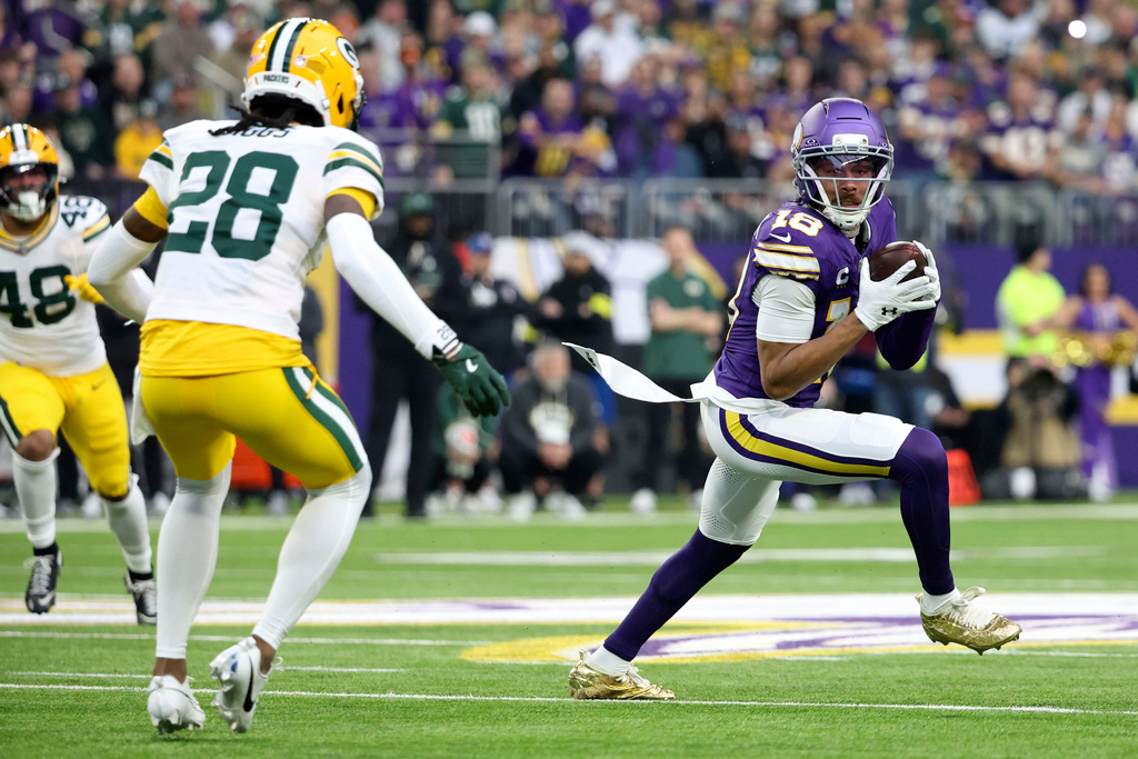 Minnesota Vikings wide receiver Justin Jefferson (18) runs from Green Bay Packers cornerback Trevon Diggs (28) after catching a pass during the first half of an NFL football game, Sunday, Jan. 4, 2026, in Minneapolis. (AP Photo/Ellen Schmidt)
