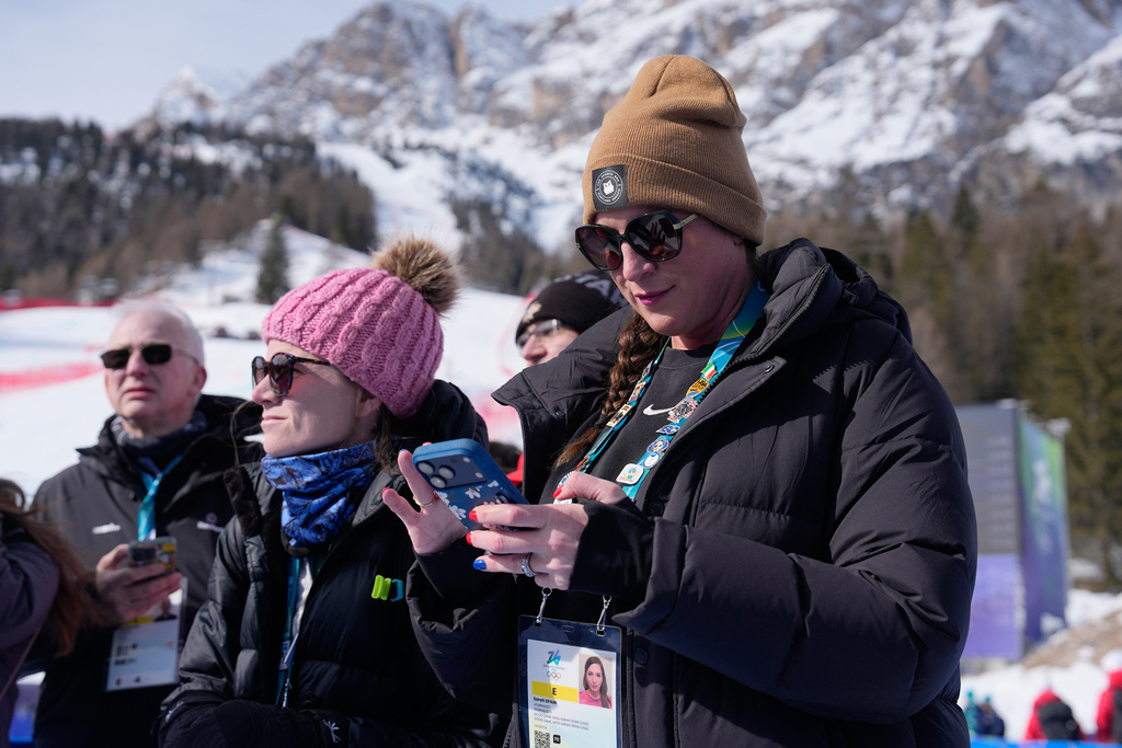 CORRECTS TO IHEART'S FROM ESPN - iHeart's Sarah Spain and her producer, Alex Azzi, wait to interview the athletes after the first run of an alpine ski women's giant slalom race at the 2026 Winter Olympics in Cortina d'Ampezzo, Italy, Sunday, Feb. 15, 2026. (AP Photo/Andy Wong)