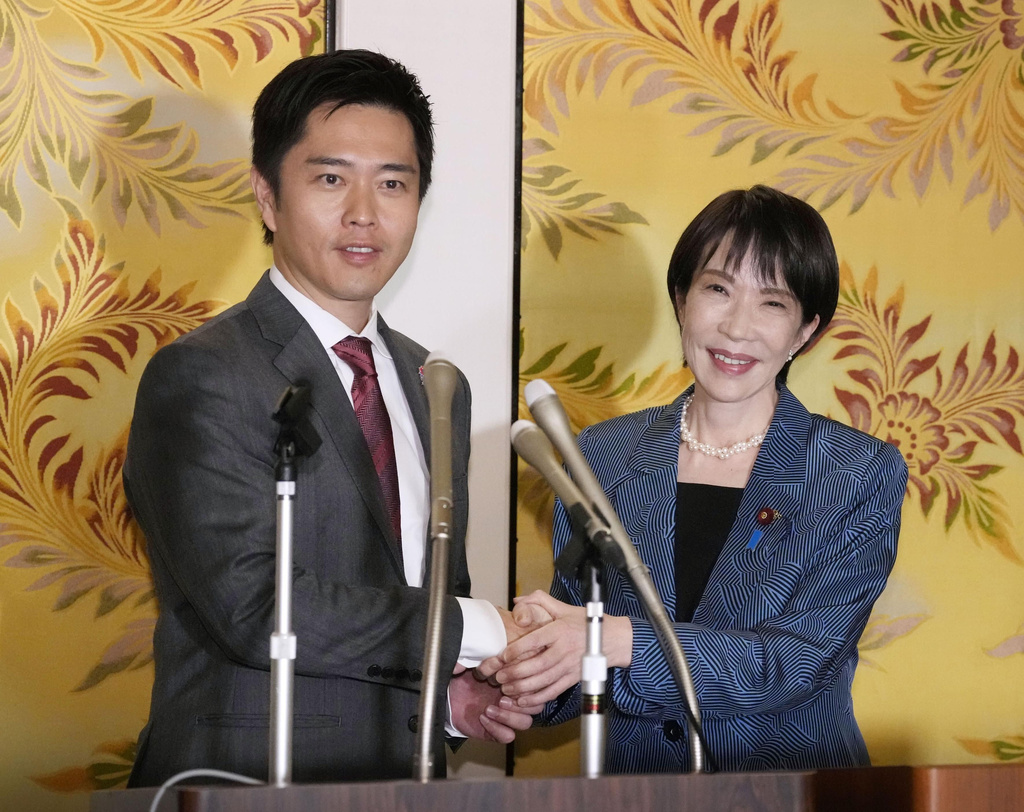 Japan’s Liberal Democratic Party President Sanae Takaichi, right, and leader of Japan Innovation Party, or Ishin no Kai, Hirofumi Yoshimura shake hands during a press conference after they signed an agreement to form a coalition government in Tokyo, Monday, Oct. 20, 2025. (Kyodo News via AP)