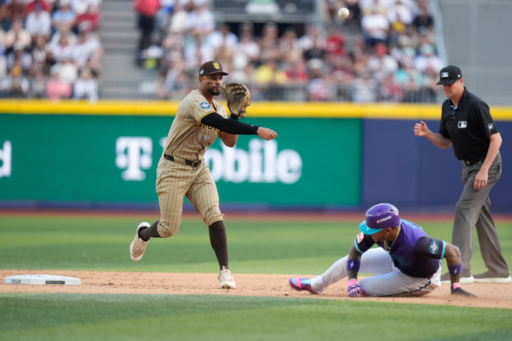 San Diego Padres' Xander Bogaerts, left, throws the ball to first base after tagging Arizona Diamondbacks' Ketel Marte out during the fifth inning of a baseball game in Mexico City, Saturday, April 25, 2026. (AP Photo/Fernando Llano)