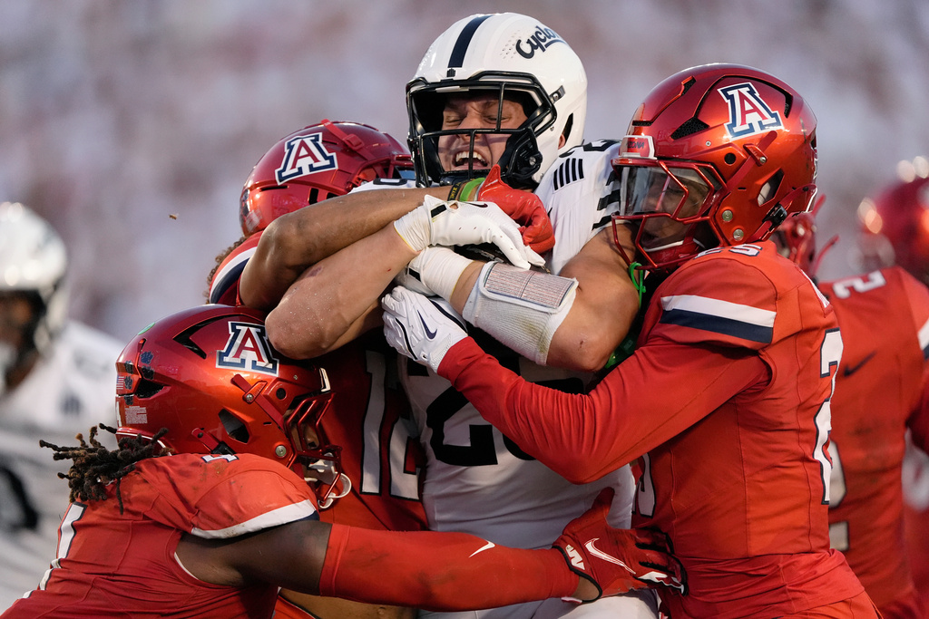 Iowa State running back Carson Hansen (26) pulls for more yards as he is stoped up by Arizona linebacker Max Harris (4) and defensive back Michael Dansby (25) during the first half of an NCAA college football game, Saturday, Sept. 27, 2025, in Ames, Iowa. (AP Photo/Matthew Putney)