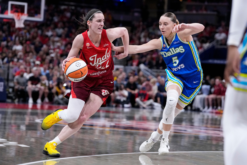 Indiana Fever guard Caitlin Clark, left, drives against Dallas Wings guard Paige Bueckers (5) in the first half of a WNBA basketball game in Indianapolis, Friday, Aug. 14, 2026. (AP Photo/Michael Conroy)