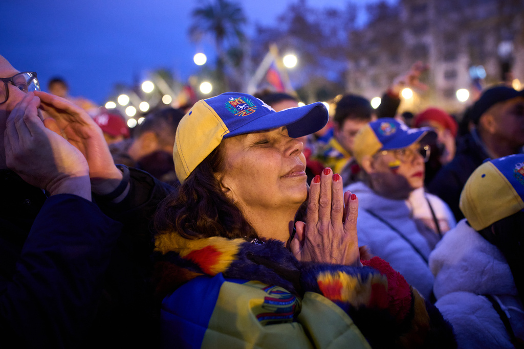 A woman reacts as people gather against Venezuelan President Nicolás Maduro in downtown Barcelona, Spain, Sunday, Jan. 4, 2026. (AP Photo/Emilio Morenatti)