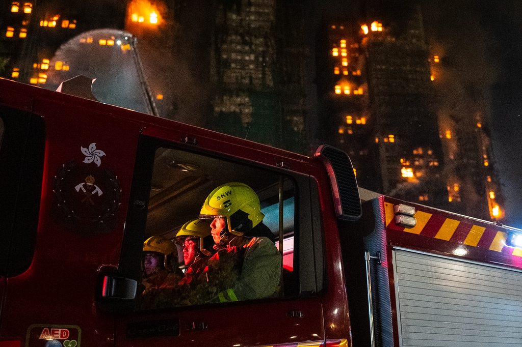 Firefighters rest at the fire truck after a fire broke out at Wang Fuk Court, a residential estate in the Tai Po district of Hong Kong's New Territories, Wednesday, Nov. 26 2025. (AP Photo/Chan Long Hei)