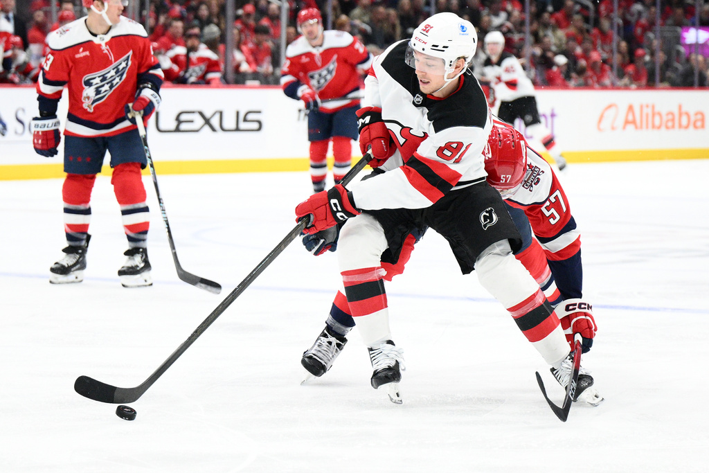 New Jersey Devils right wing Arseny Gritsyuk (81) skates with the puck past Washington Capitals defenseman Trevor van Riemsdyk (57) during the second period of an NHL hockey game, Saturday, Nov. 15, 2025, in Washington. (AP Photo/Nick Wass)
