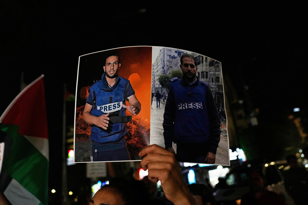 FILE - A woman holds a poster showing Palestinian journalists Anas al-Sharif, left, and Mohamed Qreiqeh, during a protest in the West Bank city of Ramallah Monday, Aug. 11, 2025, after they were killed in an Israeli airstrike late Sunday in Gaza. (AP Photo/Nasser Nasser, File)