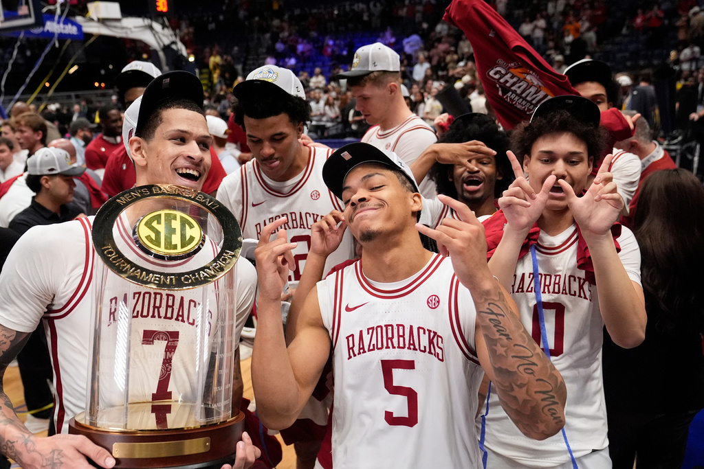 Arkansas' Trevon Brazile (7), Darius Acuff Jr. (5) and Jaden Karuletwa (0) celebrate after beating Vanderbilt in an NCAA college basketball game in the final of the Southeastern Conference tournament Sunday, March 15, 2026, in Nashville, Tenn. (AP Photo/George Walker IV)