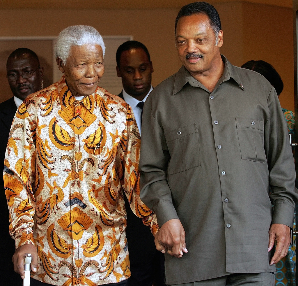 FILE - Former South African President Nelson Mandela, left, walks with the Rev. Jesse Jackson after their meeting in Johannesburg, South Africa, Oct. 26, 2005. (AP Photo/Themba Hadebe, File)