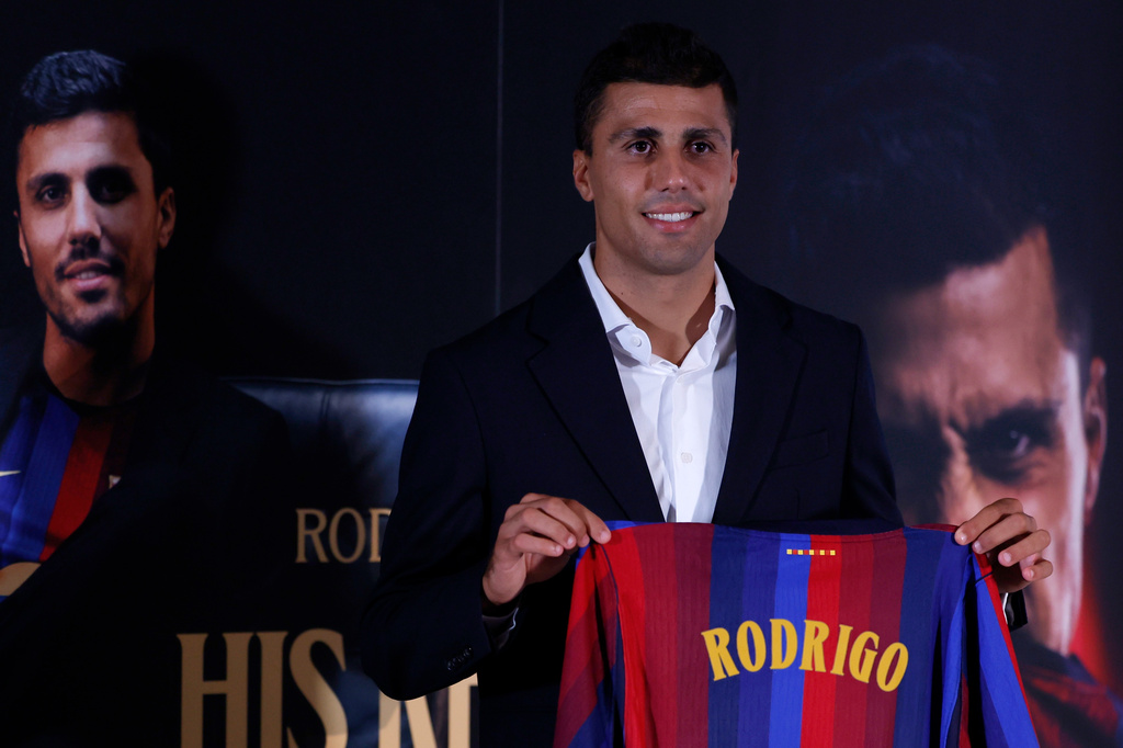 Barcelona's Rodri poses with his jersey during his official presentation at a soccer press conference in Barcelona, Spain, Tuesday, Aug. 18, 2026. (AP Photo/Joan Monfort)