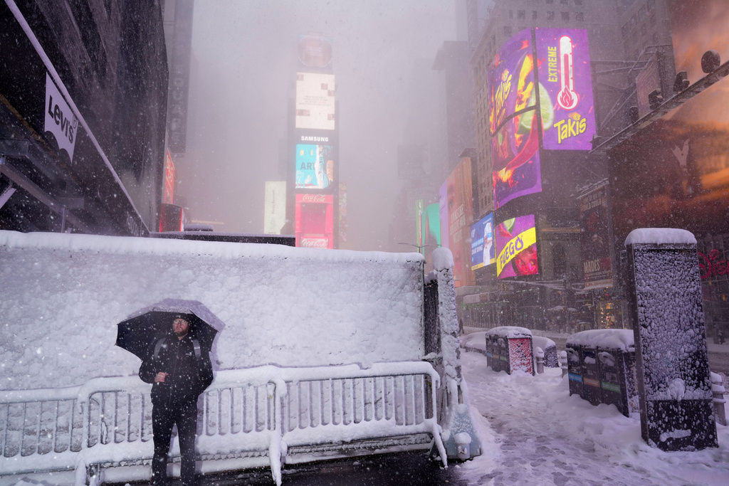 A man pauses while walking through Times Square during a snow storm, Monday, Feb. 23, 2026, in New York. (AP Photo/Seth Wenig)