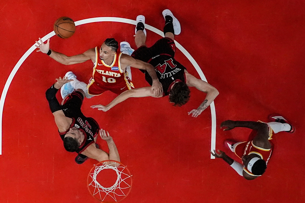 Atlanta Hawks forward Zaccharie Risacher (10) and Chicago Bulls forward Matas Buzelis (14) vie for a loose ball during the first half of an NBA basketball game, Tuesday, Dec. 23, 2025, in Atlanta. (AP Photo/Mike Stewart)
