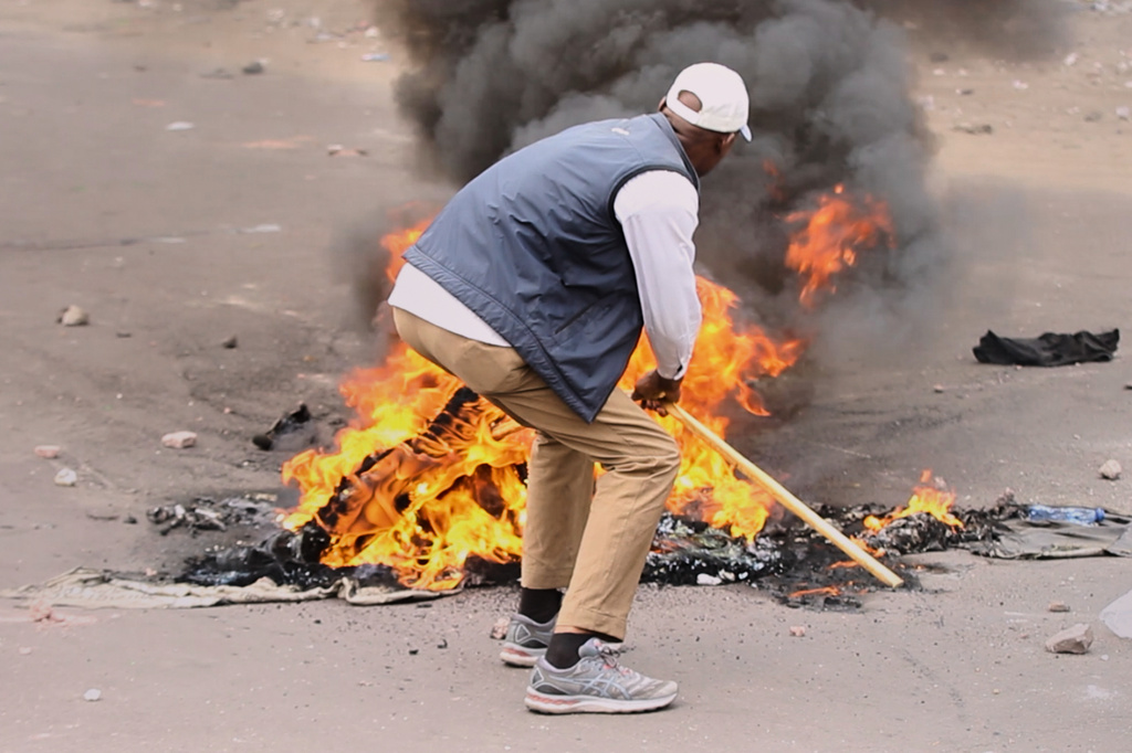 A protester sets a fire in the middle of the road during a demonstration as Congo's opposition rejects a proposed constitutional change in Kinshasa, Congo, Friday, June 12, 2026. (AP Photo/Ekutshu Yannick)