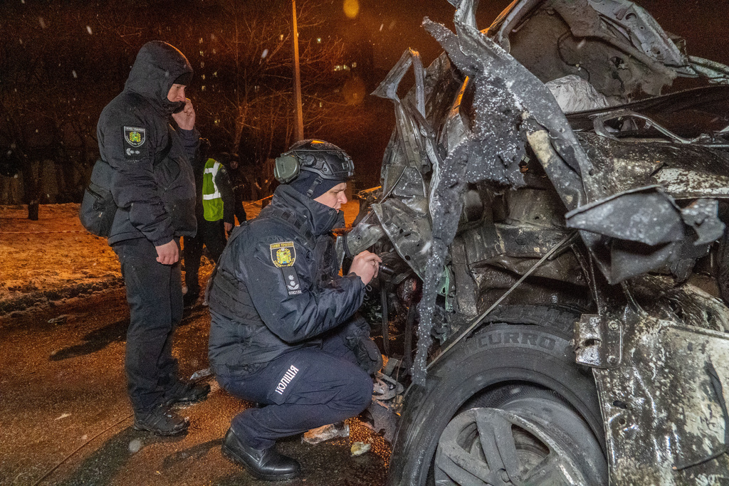 Police officers inspect the damaged vehicle hit by Russian airstrike in Kharkiv, Ukraine, Friday, Dec. 26, 2025. (AP Photo/Andrii Marienko)
