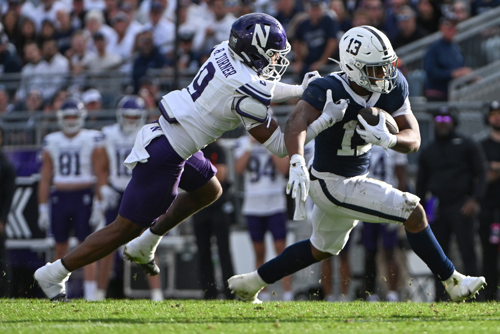 Penn State running back Kaytron Allen (13) runs away from Northwestern defensive back Braden Turner (9) during the second quarter of an NCAA college football game, Saturday, Oct. 11, 2025, in State College, Pa. (AP Photo/Barry Reeger)