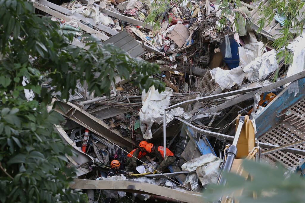 Rescuers retrieve a body inside a collapsed waste segregation facility in Binaliw, Cebu city, central Philippines on Friday, Jan. 9, 2026. (AP Photo/Jacqueline Hernandez)
