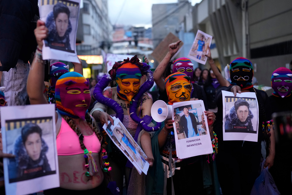 Women hold photos of people who they accuse of being victimizers of women during a march marking the upcoming International Women's Day, in La Paz, Bolivia, Friday, March 6, 2026. (AP Photo/Juan Karita)