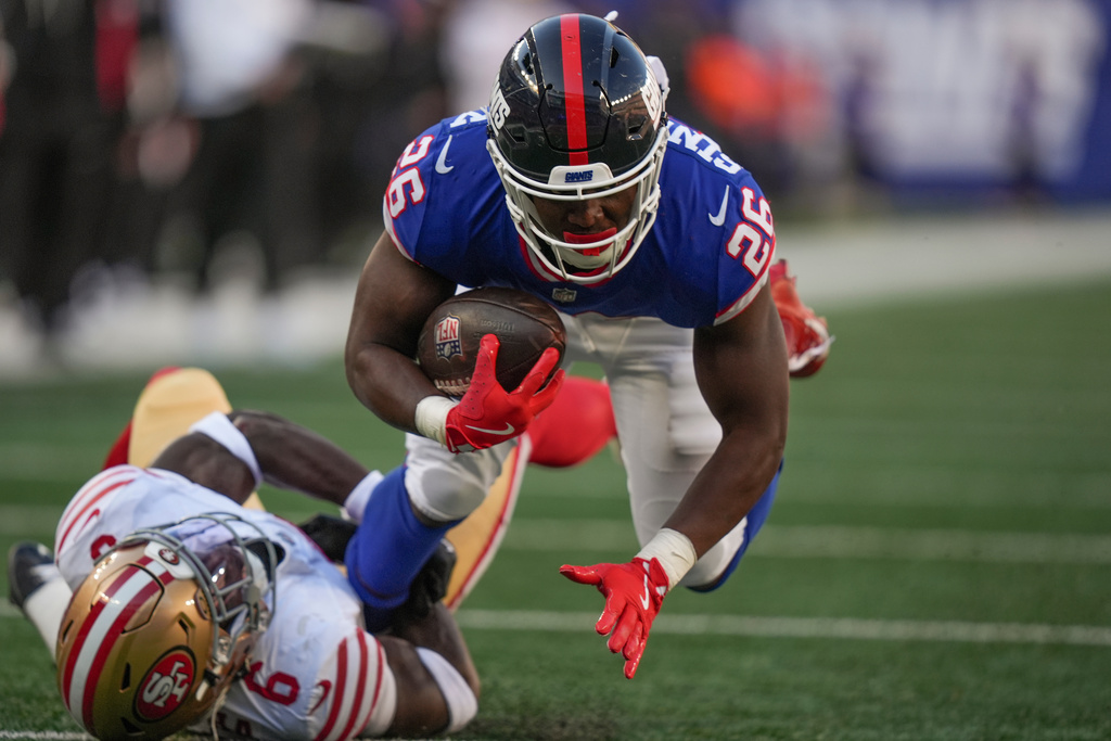 New York Giants running back Devin Singletary (26) is tackled by San Francisco 49ers safety Malik Mustapha (6) during the third quarter of an NFL football game, Sunday, Nov. 2, 2025, in East Rutherford, N.J. (AP Photo/Frank Franklin II)