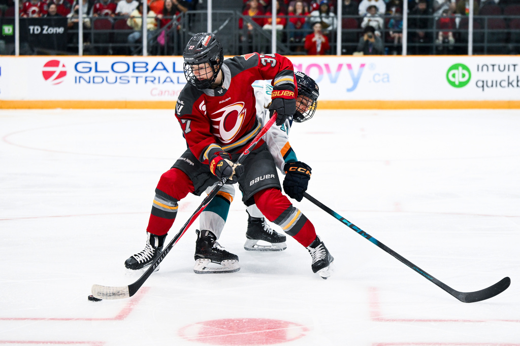 Ottawa Charge's Rebecca Leslie (37) works under pressure from New York Sirens' Nicole Vallario (11) during the first period a PWHL hockey game in Ottawa, Ontario, Saturday, April 18, 2026. (Spencer Colby/The Canadian Press via AP)
