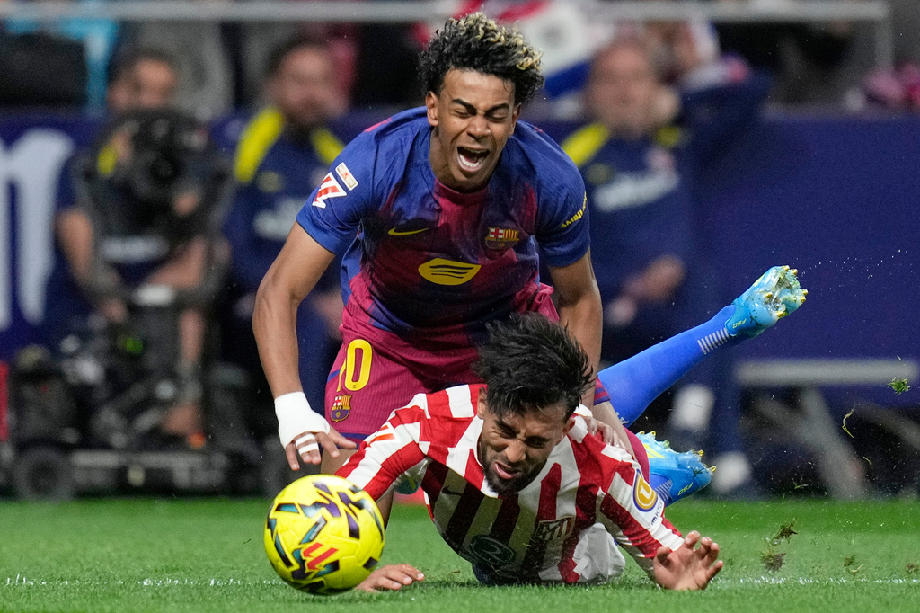 Barcelona's Lamine Yamal, top is tackled and fouled by Atletico Madrid's Nico Gonzalez, who receives a second yellow card and is then sent off during a La Liga soccer match between Atletico Madrid and Barcelona in Madrid, Spain, Saturday, April 4, 2026. (AP Photo/Bernat Armangue)